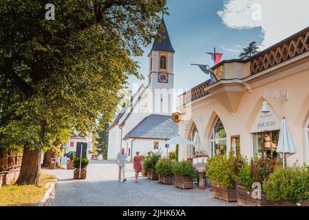 Vista su una strada a Collalbo, sullo sfondo la chiesa di Sant'Antonio - Chiesa di Sant'Antonio. Collalbo, Klobenstein in tedesco, è una frazione, un Foto Stock
