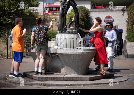 London Heatwave la gente si raffredda con acqua fredda presso una fontana al di fuori della stazione della metropolitana di Green Park oggi, quando le temperature raggiungono i 37C in alcune delle condizioni meteorologiche più calde mai raggiunte nel Regno Unito. 19th luglio 2022 Londra, Regno Unito Foto Stock