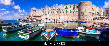 Italia tradizionale. Regione della Puglia atmosferica con villaggi bianchi e variopinte barche da pesca. Comune di Giovinazzo, provincia di Bari Foto Stock