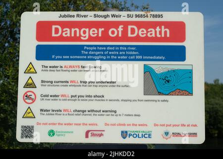 Slough, Berkshire, Regno Unito. 19th luglio 2022. Pericolo di morte segni accanto a uno stramazzo sul fiume Jubilee a Slough, Berkshire. Con il raggiungimento delle temperature record oggi, più giovani si dirigeranno verso i fiumi per raffreddarsi, ma alcuni di essi potrebbero mettere a rischio la propria vita nuotando in acqua aperta. Un ragazzo è morto ieri a Bray Lake e un ragazzo è morto anche nel fiume Jubilee recentemente. Credit: Maureen McLean/Alamy Live News Foto Stock