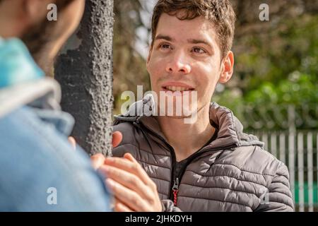 Coppia latina gay divertirsi in un parco che si guarda l'un l'altro Foto Stock