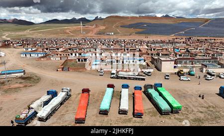 (220719) -- NAGQU, 19 luglio 2022 (Xinhua) -- Foto aerea scattata il 13 luglio 2022 mostra camion che trasportano mobili che si preparano a partire da Doima Township della contea di Tsonyi, regione autonoma del Tibet della Cina sud-occidentale. La contea di Tsonyi, la regione autonoma del Tibet della Cina sudoccidentale, ha iniziato il trasferimento della sua seconda serie di residenti martedì, come parte del piano della regione per migliorare le condizioni di vita delle persone e proteggere il fragile ecosistema locale. Con un'altitudine media di oltre 5.000 metri, la contea di Tsonyi copre un'area totale di 120.000 km quadrati ed è parte del Changtang National Nature Res Foto Stock