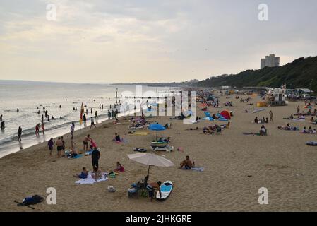 Boscombe, Bournemouth, Dorset, Inghilterra, Regno Unito, 19th luglio 2022, Meteo. L'estremità è vicina all'onda termica che si rompe da record. Nuvole scure e una doccia a pioggia su una spiaggia trafficata nel pomeriggio ha persone che usano ombrelloni da pioggia. Credit: Paul Biggins/Alamy Live News Foto Stock