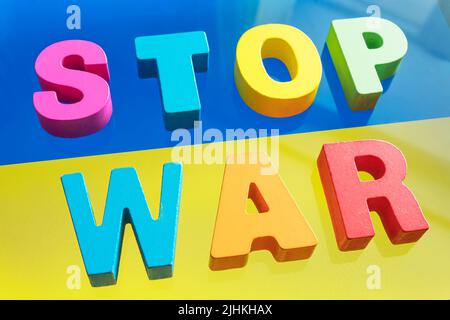 Frase Stop War su sfondo bandiera ucraino . Fermare la guerra in Ucraina. Foto Stock