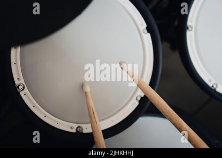 tamburi e bastoni elettronici su sfondo scuro. Suonare i tamburi di addestramento. Foto Stock