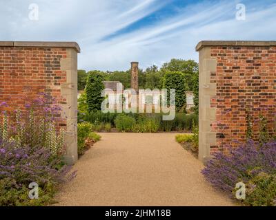 Guardando attraverso un'apertura nel muro nel giardino paradiso di RHS Bridgewater a Salford. REGNO UNITO Foto Stock