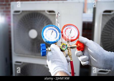 Tecnico dell'aria condizionata industriale. Riparazione dell'impianto di raffreddamento HVAC Foto Stock