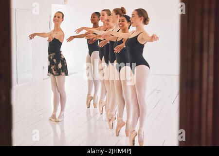 Giovane insegnante di danza donna che insegna una classe di balletto a un gruppo di bambini nel suo studio. Ballerina che lavora con gli studenti delle ragazze, preparandosi Foto Stock