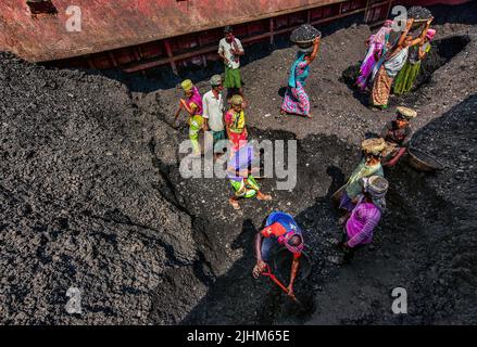 Donne lavoratrici che trasportano cestini riempiti di carbone sulla loro testa nella regione Gabboli di Dacca Foto Stock