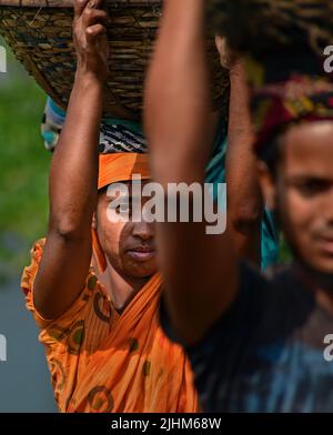 Donne lavoratrici che trasportano cestini riempiti di carbone sulla loro testa nella regione Gabboli di Dacca Foto Stock