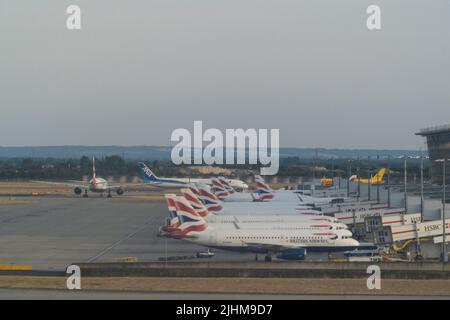 Al Terminal 5 dell'Aeroporto di Heathrow gli aerei della British Airways sono allineati alle porte. Poiché le scuole di stato stanno per iniziare le vacanze estive, gli aeroporti saranno sotto pressione quando le famiglie inizieranno le loro vacanze e molti voli sono già stati cancellati a causa della carenza di personale tra il personale di terra e i gestori bagagli a Heathrow e in altri aeroporti. Anna Watson/Alamy Foto Stock