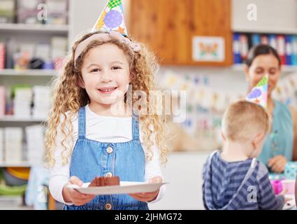 La torta fa sorridere a tutti. Un bambino prescolare festeggia un compleanno in classe. Foto Stock