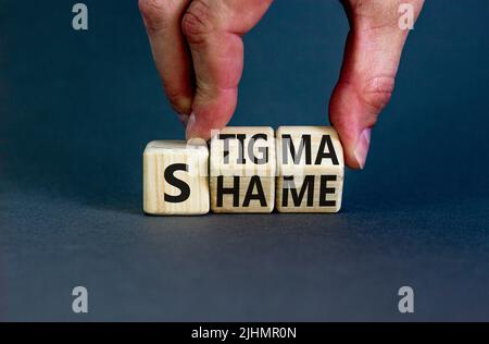 Stigma o simbolo di vergogna. Concetto parole stigma o vergogna su cubi di legno. Mano dell'uomo d'affari. Bello sfondo grigio tavolo. Business stigma o sham Foto Stock