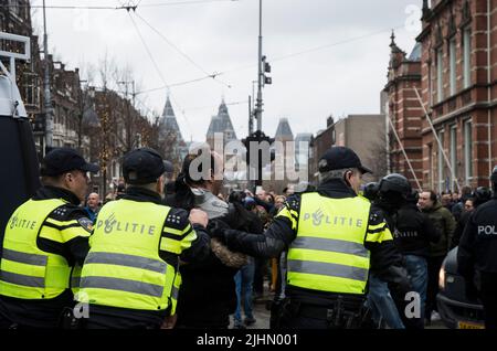 01022022,Amsterdam,Paesi Bassi. Dimostrazione delle misure antivideo. La protesta era proibita a causa di 19 misure, ma migliaia di persone si recavano al Museumplein. La piazza è stata designata un'area ad alto rischio, dove la polizia ha cercato tutti e ha chiesto di I.D quando la polizia ha concluso la protesta, i manifestanti hanno marciato nella città, ma sono stati fermati dalla polizia sommossa. Si è verificato un confronto e sono stati utilizzati poliziotti. Alcune persone sono state ferite e diverse sono state arrestate. Molti marciarono più in città e alcuni andarono al rally di FVD, un partito politico, che si tenne anche quel giorno Foto Stock