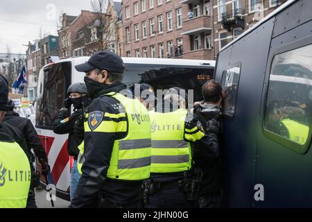 01022022,Amsterdam,Paesi Bassi. Dimostrazione delle misure antivideo. La protesta era proibita a causa di 19 misure, ma migliaia di persone si recavano al Museumplein. La piazza è stata designata un'area ad alto rischio, dove la polizia ha cercato tutti e ha chiesto di I.D quando la polizia ha concluso la protesta, i manifestanti hanno marciato nella città, ma sono stati fermati dalla polizia sommossa. Si è verificato un confronto e sono stati utilizzati poliziotti. Alcune persone sono state ferite e diverse sono state arrestate. Molti marciarono più in città e alcuni andarono al rally di FVD, un partito politico, che si tenne anche quel giorno Foto Stock