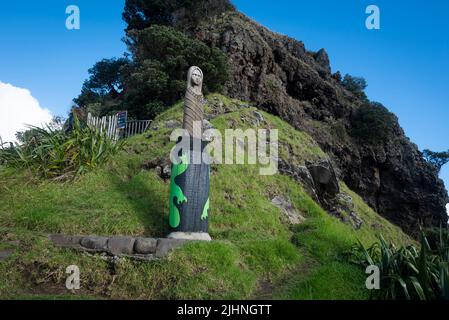 Una scultura nel punto più alto della roccia della testa del Leone alla spiaggia di Piha, Nuova Zelanda. Foto Stock