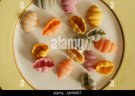 Conchiglie di Conchiglie di Conchiglioni di mare secco Pasta colorata, spinaci, barbabietole, curcuma e paprika per colorare la pasta verde, rosa, giallo, arancio Foto Stock