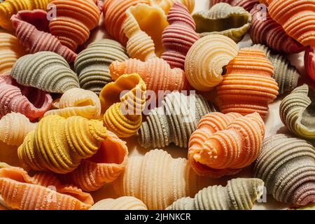 Conchiglie di Conchiglie di Conchiglioni di mare secco Pasta colorata, spinaci, barbabietole, curcuma e paprika per colorare la pasta verde, rosa, giallo, arancio Foto Stock