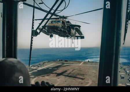 Un elicottero UH-60 Black Hawk assegnato alla Joint Task Force-Bravo’s 1-228th Aviation Regiment atterra sul ponte della nave da combattimento litoranea variante Freedom USS Billings (LCS 15) durante la formazione di qualificazione di atterraggio al largo della costa di El Salvador, 16 luglio 2022. Il raggiungimento e il mantenimento delle qualifiche di atterraggio sul ponte garantiscono che gli equipaggi di volo siano pronti a sostenere qualsiasi assistenza umanitaria, soccorso in caso di calamità o altre operazioni di emergenza in tutta l'area di responsabilità del comando meridionale degli Stati Uniti. (STATI UNITI Foto Navy di Master-at-Arms 1st Classe John Carson) Foto Stock