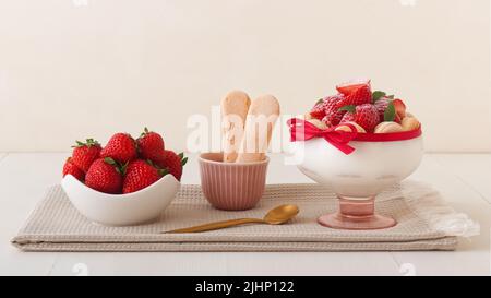 Charlotte, dessert francese con fragole legate con nastro di scarlatto, dessert facile e veloce fatto in un bicchiere. Foto Stock