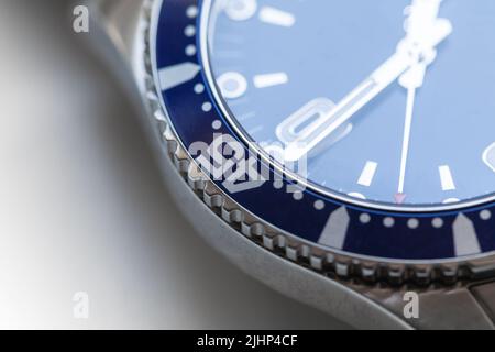 Orologio meccanico automatico svizzero da polso frammento con rivestimento blu e cornice in ceramica rotante. Foto primo piano con soft focus selettivo Foto Stock