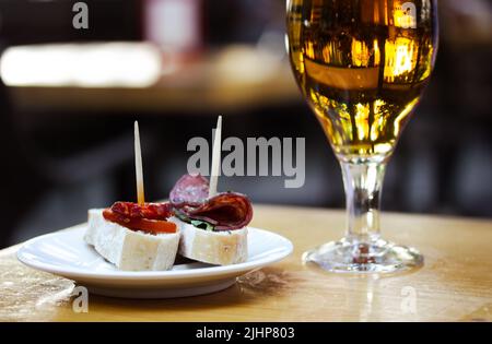 Birra ambrata in bicchiere. Eleganti stoviglie con birra di grano fresca dorata si trova su un tavolo di legno nella caffetteria, bar e terrazza. Bevanda alcolica con Foto Stock