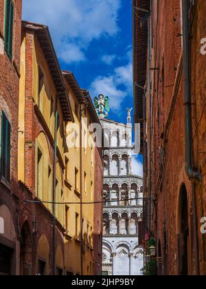 Vista di Lucca affascinante centro storico strada stretta con la bella chiesa medievale di San Michele Foto Stock