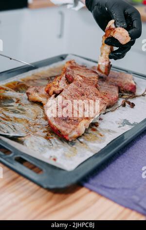 Bistecca di manzo con verdure su un piatto nero. Bistecca con basilico cucinata nella lezione di cucina Foto Stock