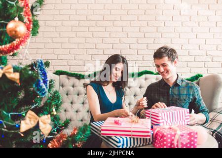 Uomo sorridente e donna che confezionano regali, spazio libero Foto Stock