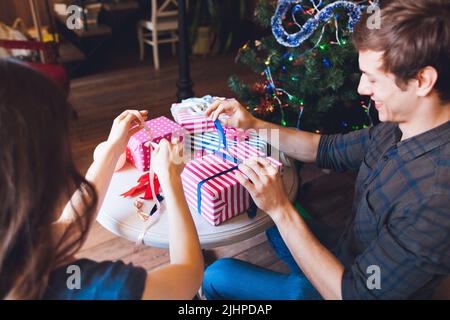 L'uomo sorridente che impacchettava presenta con la moglie Foto Stock