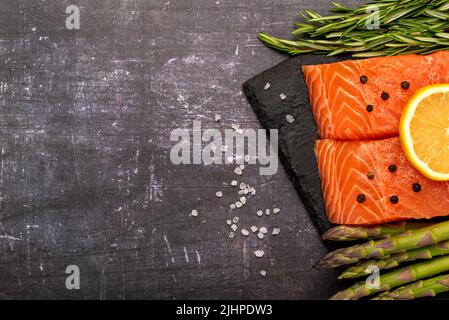 Fotografia in bianco di salmone crudo, asparagi, rosmarino, limone Foto Stock