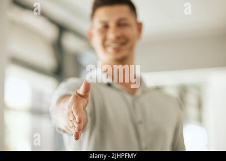 Primo piano di un uomo d'affari che allunga il braccio offrendo una stretta di mano per dare il benvenuto a un nuovo partner mentre si trova in ufficio. Saluto o assunzione del responsabile delle risorse umane per Foto Stock