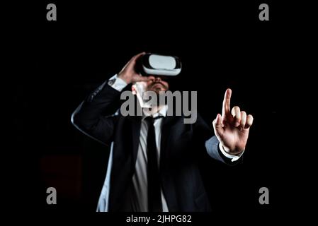 Uomo d'affari che indossa le cuffie per realtà virtuale gesturando e seguendo la formazione professionale attraverso il simulatore. Uomo in tuta che presenta la tecnologia moderna di Foto Stock