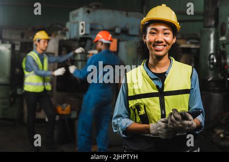 Ingegnere donna che tiene tablet e sorridere in fabbrica industria lavorare duro concetto Foto Stock