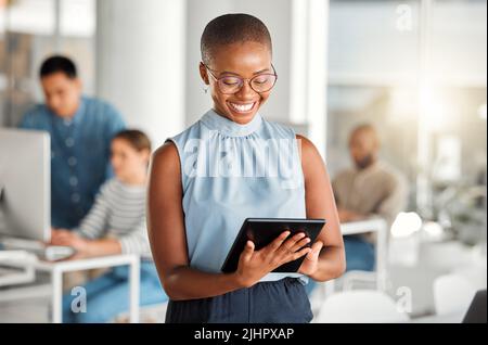 Allegra donna d'affari afroamericana che lavora su un tablet digitale al lavoro. Gioiosa donna d'affari nera che usa i social media su un tablet digitale Foto Stock