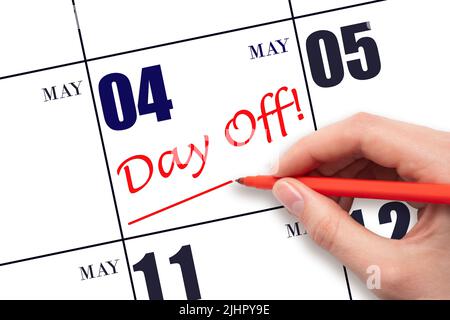 4th maggio. Scrivere a mano il testo GIORNO OFF e disegnare una linea sulla data di calendario 4 maggio. Concetto di pianificazione delle vacanze. Mese di primavera, giorno dell'anno concetto. Foto Stock