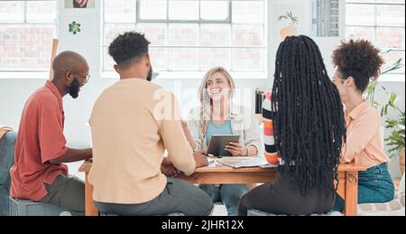 Gruppo di uomini d'affari diversi che hanno una riunione in un ufficio moderno al lavoro. Giovane felice donna d'affari caucasica sorridente mentre lavora su un digitale Foto Stock