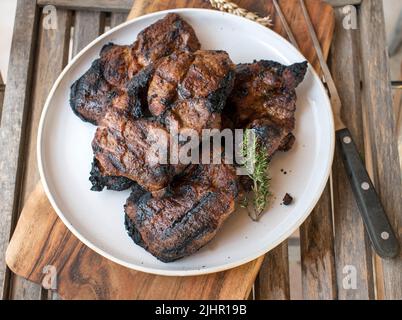 Bistecche fresche di maiale alla griglia su un piatto Foto Stock