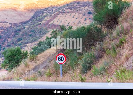 Vista di un cartello stradale con limite di velocità di 60 chilometri all'ora su una strada di campagna. Foto Stock