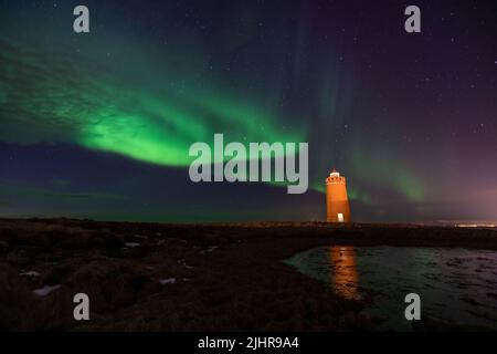 Faro sulla penisola di Reykjanes nortern sotto le luci. L'Islanda. Il timelapse Foto Stock