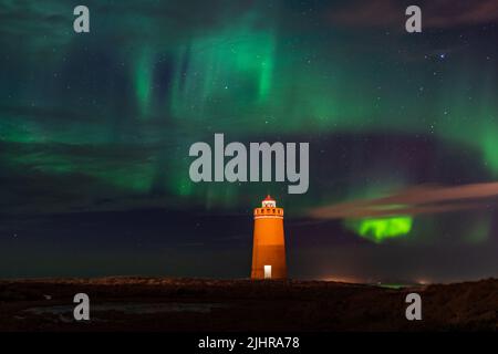 Faro sulla penisola di Reykjanes nortern sotto le luci. L'Islanda. Il timelapse Foto Stock