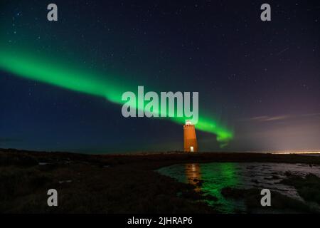 Faro sulla penisola di Reykjanes nortern sotto le luci. L'Islanda. Il timelapse Foto Stock