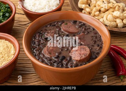 Tipica feijoada brasiliana con cavolo, riso e crackling. Foto Stock