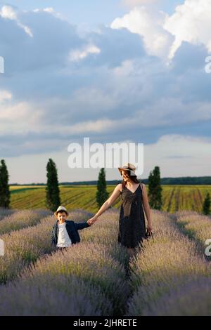 Ragazzo che cammina con la madre su un campo di lavanda Foto Stock