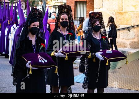 Un primo piano di donne che portano le unghie, corona di spine e martello in Spagna Foto Stock