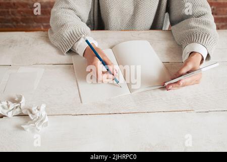 Donna irriconoscibile che scrive in taccuino mockup Foto Stock