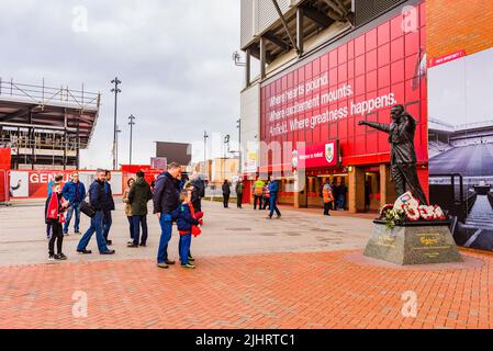 Tifosi di Liverpool F.C. accanto alla statua di Bill Shankly all'Anfield Stadium. Anfield, Liverpool, Merseyside, Lancashire, Inghilterra, Regno Unito Foto Stock