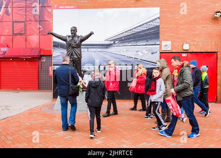 Tifosi di Liverpool F.C. accanto alla statua di Bill Shankly all'Anfield Stadium. Anfield, Liverpool, Merseyside, Lancashire, Inghilterra, Regno Unito Foto Stock