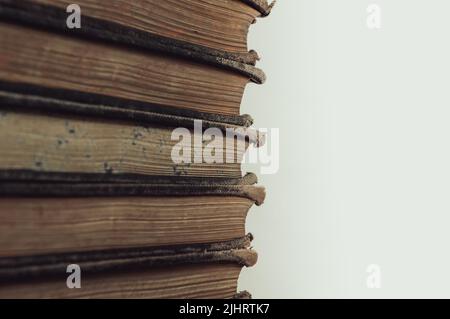 Una pila di vecchi libri su sfondo bianco Foto Stock