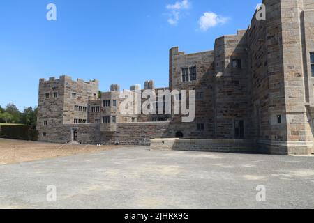 La facciata recentemente ristrutturata di una casa di campagna inglese, costruita per assomiglia ad un castello medievale ai margini del parco nazionale di Dartmoor in Devon, Inghilterra Foto Stock